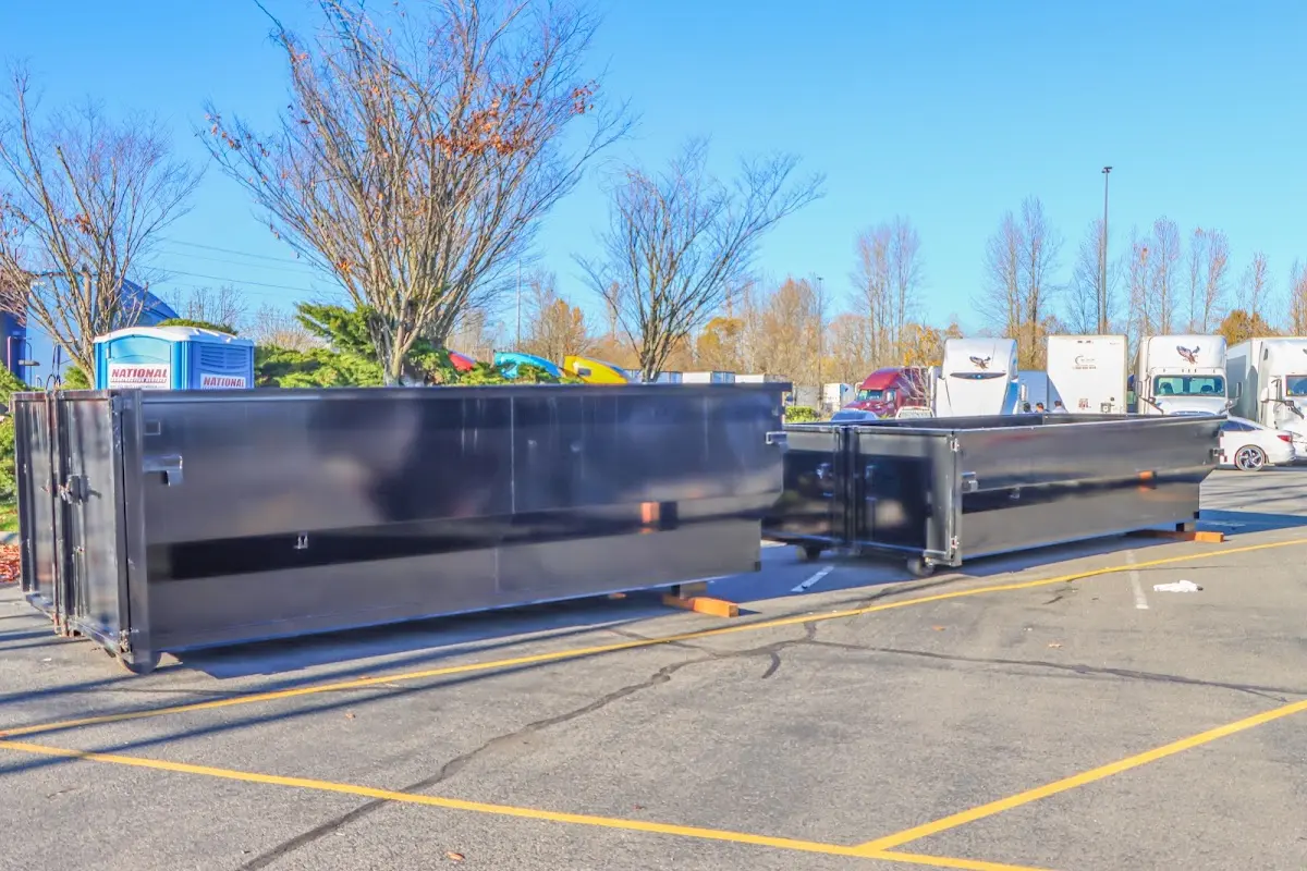 Professional dumpster rental service with roll-off container on residential driveway in Forest